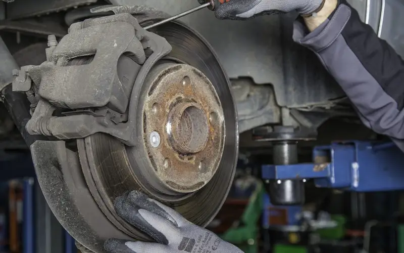 Illustration: brake caliper and rotor during a brake repair